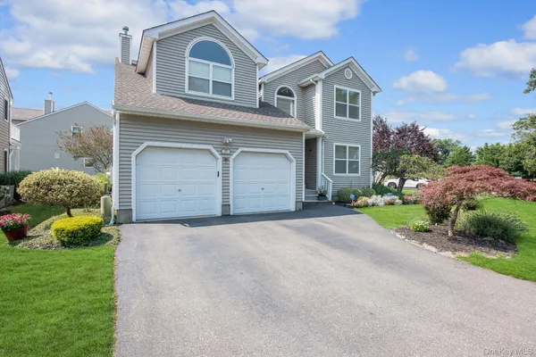 a front view of a house with a garden and garage