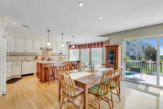 a dining hall with stainless steel appliances kitchen island granite countertop a dining table and chairs