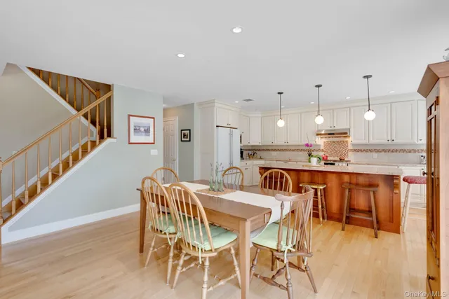 a kitchen with stainless steel appliances kitchen island granite countertop a dining table chairs and granite counter tops