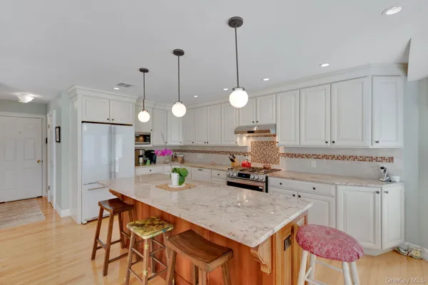 a kitchen with stainless steel appliances granite countertop a stove a refrigerator and a wooden cabinets