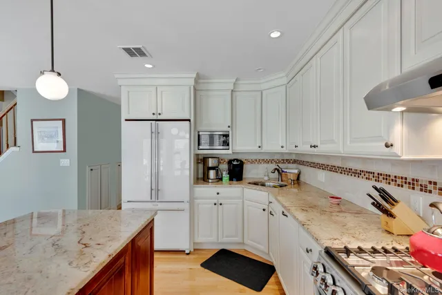 a kitchen with granite countertop a sink a stove and refrigerator