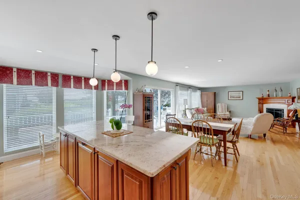 a kitchen with stainless steel appliances granite countertop a kitchen island a stove and a wooden floors