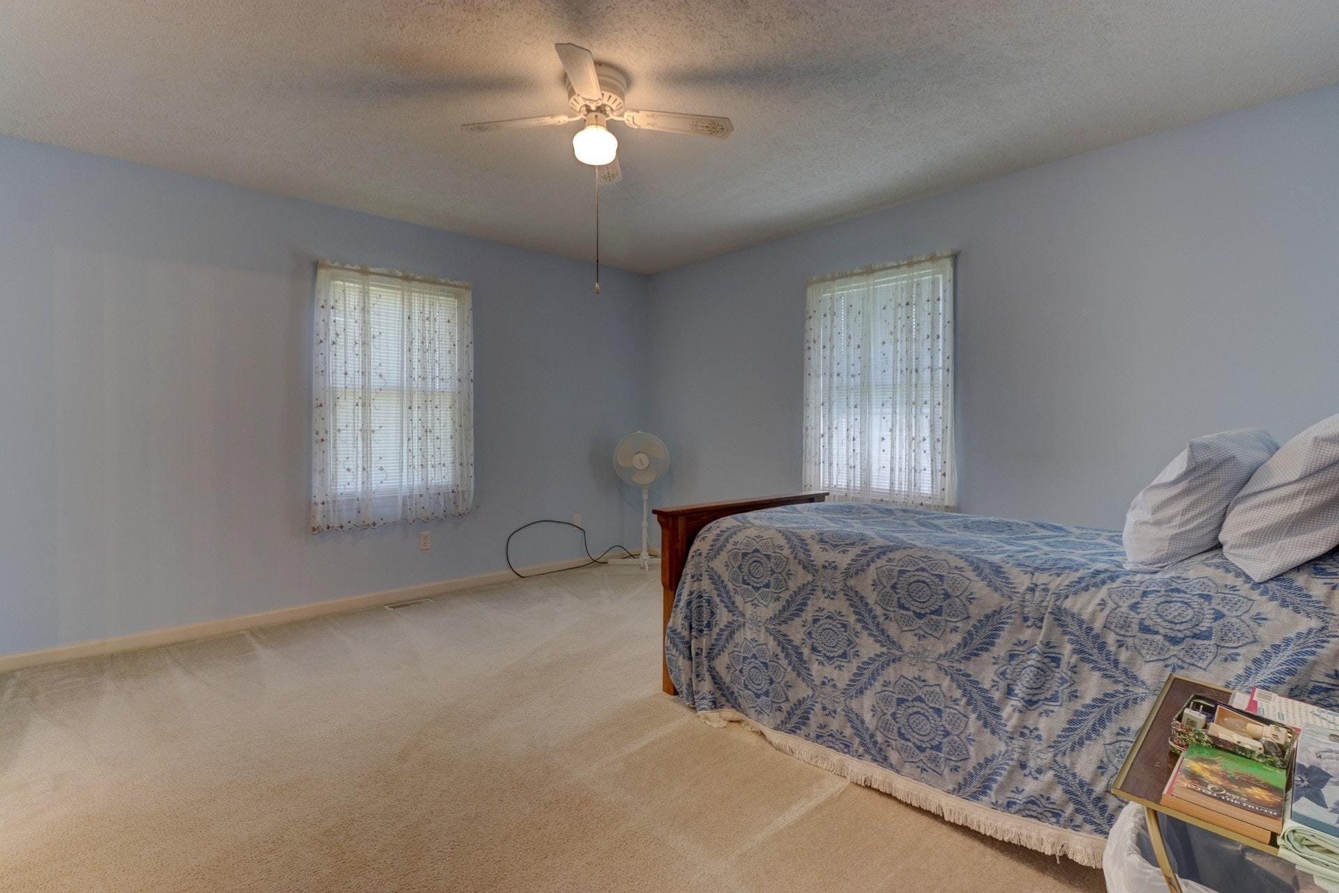 5331 Bethlehem Road Boones Mill, VA 24065 - Photo 10 of 21 a bedroom with a bed and a chandelier