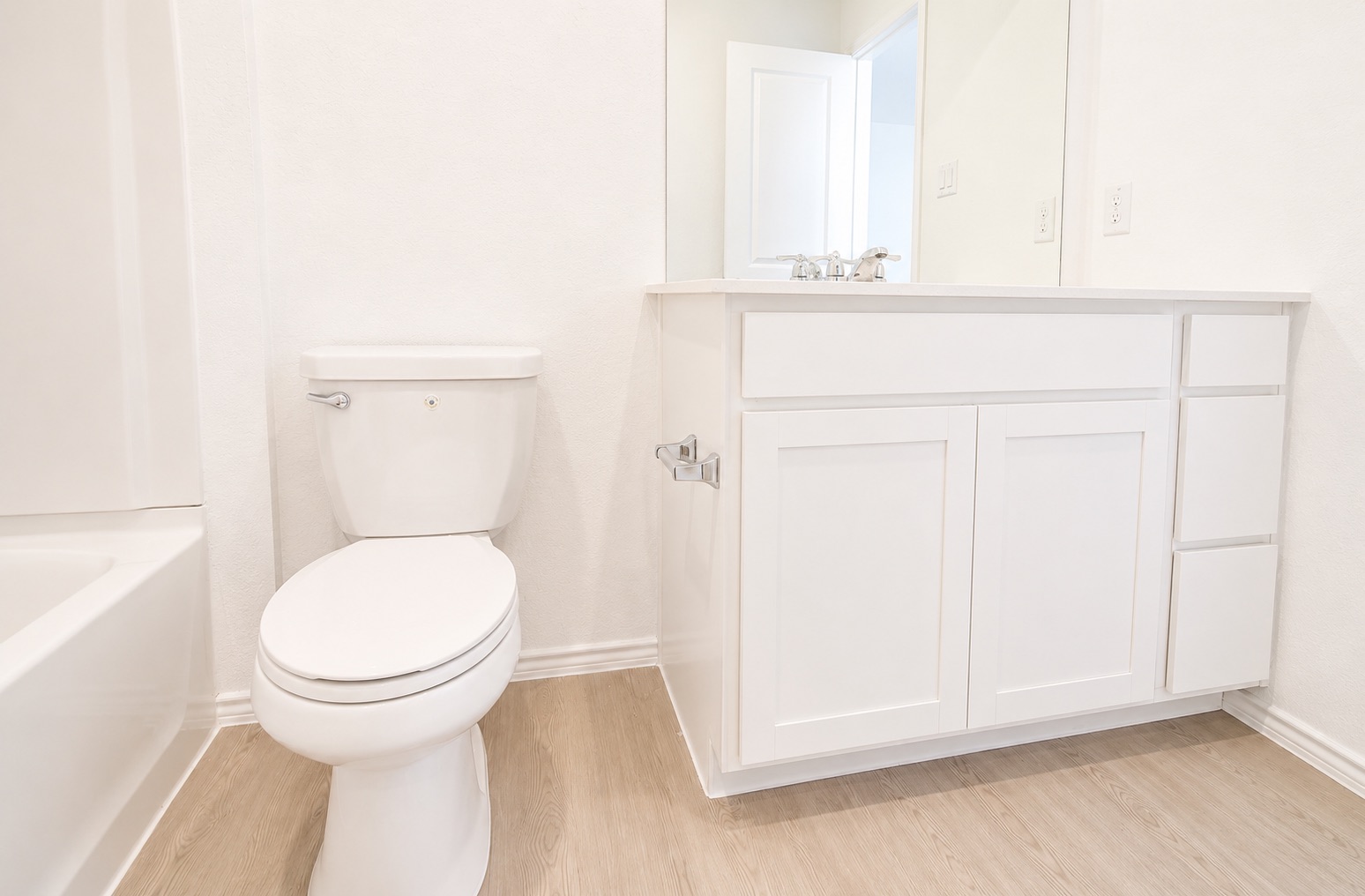 397 Keefer Kyle, TX 78640 - Photo 20 of 33 A well-lit primary bathroom featuring a clean white vanity and light wood flooring.
