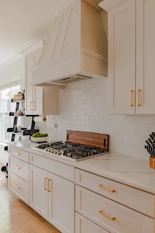 a kitchen with white cabinets and appliances