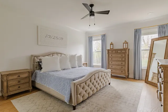 a bedroom with a bed next to a window and a flat screen tv
