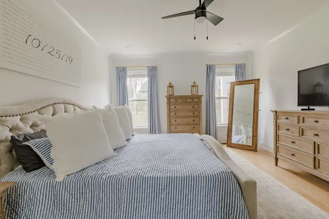 a bedroom with a bed and a flat tv screen on dresser
