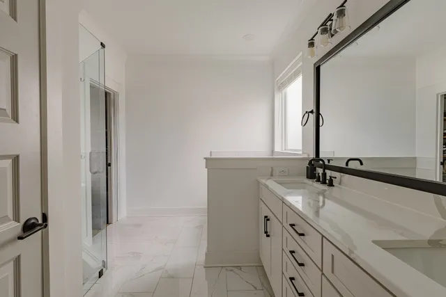 a bathroom with a double vanity sink a mirror and a bathtub