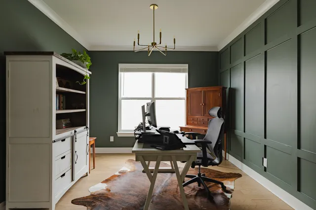 a view of a workspace with furniture and a window