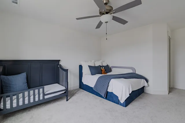 a bedroom with a bed and a ceiling fan