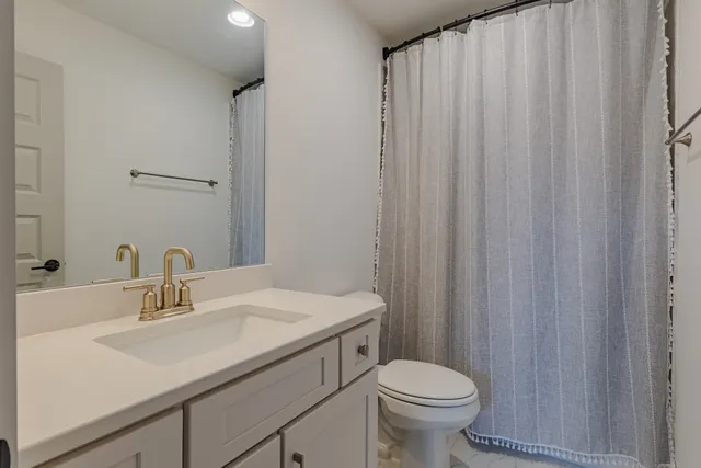 a bathroom with a sink a toilet and a mirror