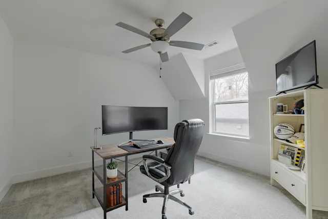 a view of a workspace with furniture and a window