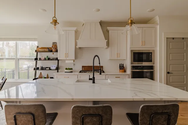 a kitchen with kitchen island a sink stove and microwave