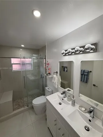 a spacious bathroom with a sink a toilet and mirror