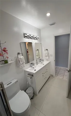 a utility room with a washer dryer and white cabinets