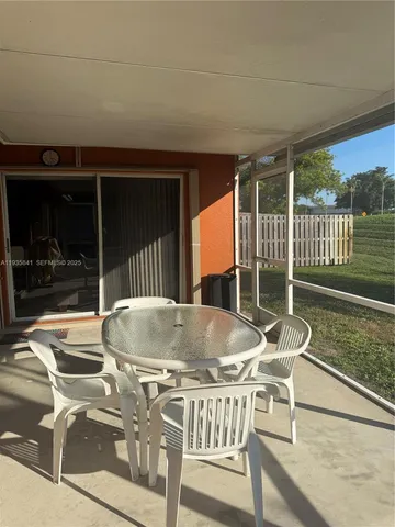a roof deck with table and chairs and wooden floor