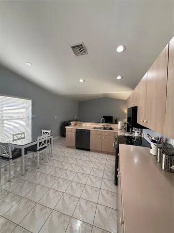 a kitchen with stainless steel appliances lots of counter top space and furniture