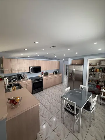 a kitchen with a sink a counter top stainless steel appliances and cabinets