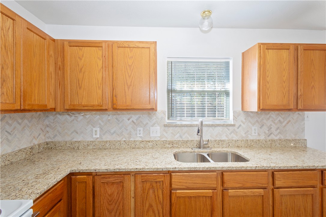 1833 Promise Corpus Christi, TX 78412 - Photo 7 of 19 a kitchen with wooden cabinets and a sink