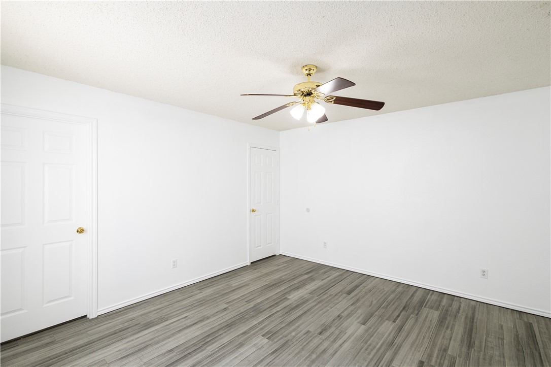 1833 Promise Corpus Christi, TX 78412 - Photo 10 of 19 an empty room with wooden floor and a ceiling fan
