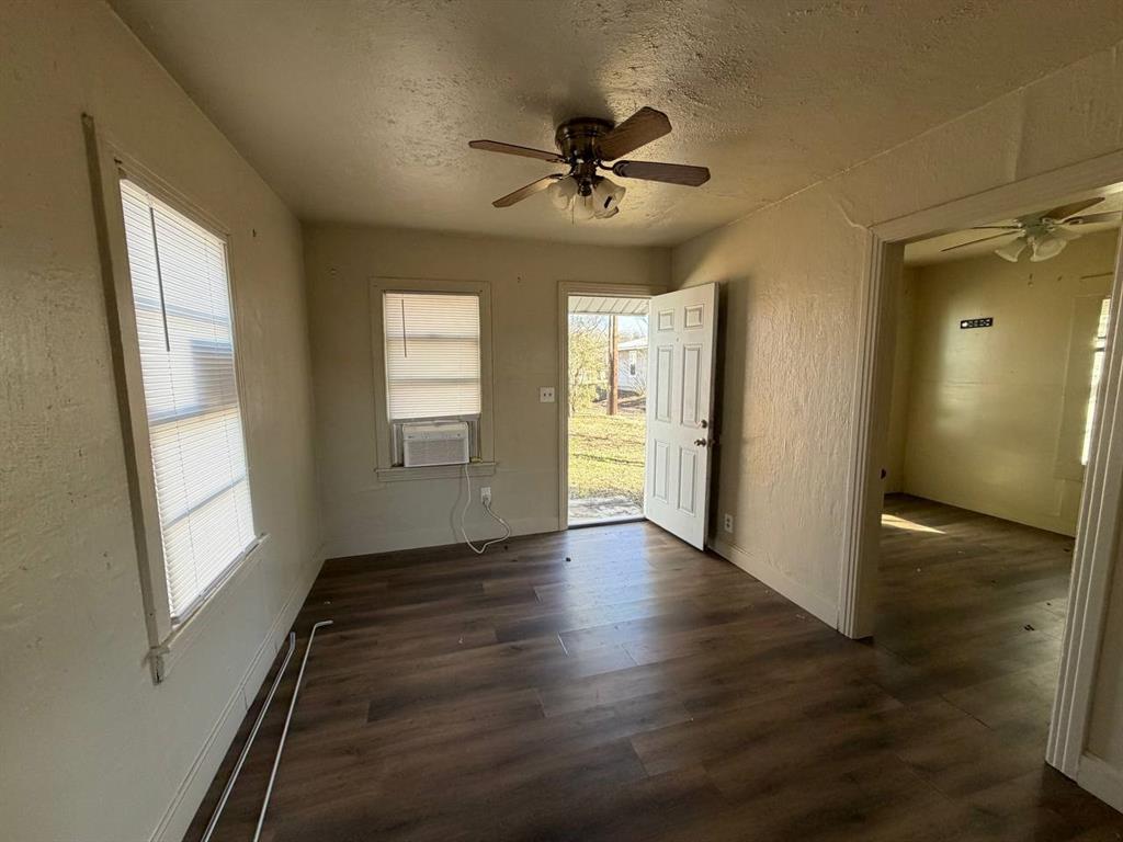 814 Tennessee Street Graham, TX 76450 - Photo 4 of 10 a view of an empty room with window and wooden floor