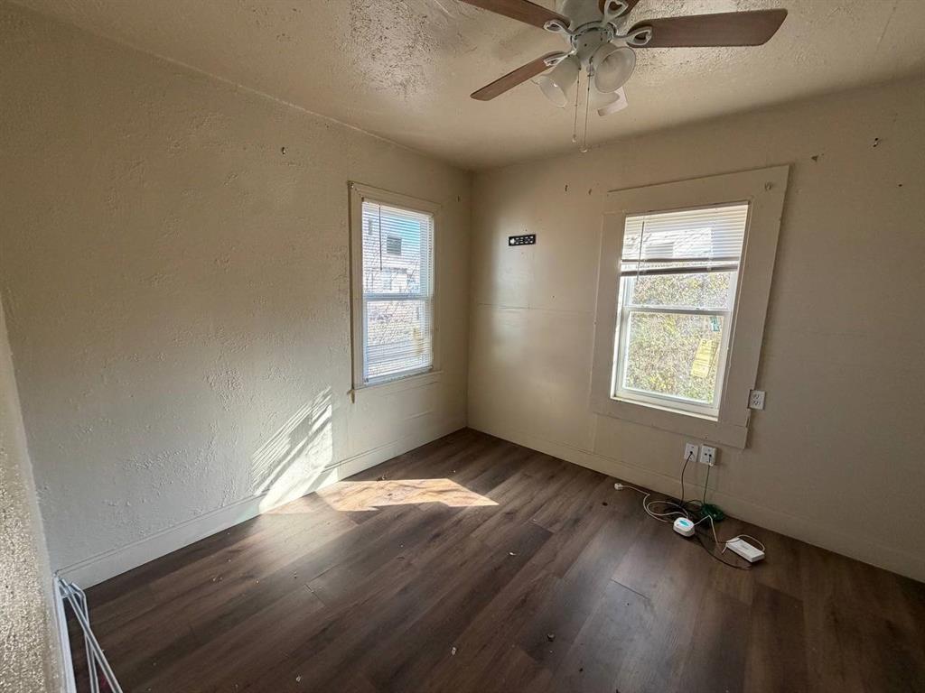 814 Tennessee Street Graham, TX 76450 - Photo 5 of 10 wooden floor in an empty room with a window