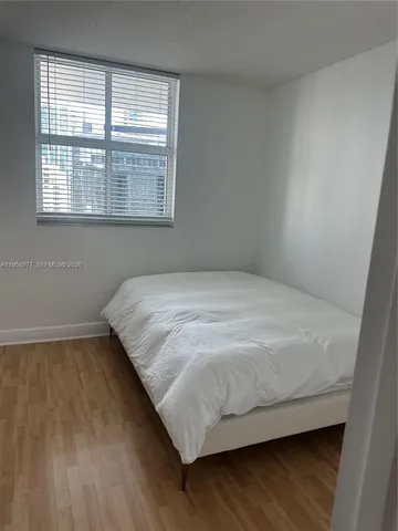 a bed sitting in a bedroom next to a window