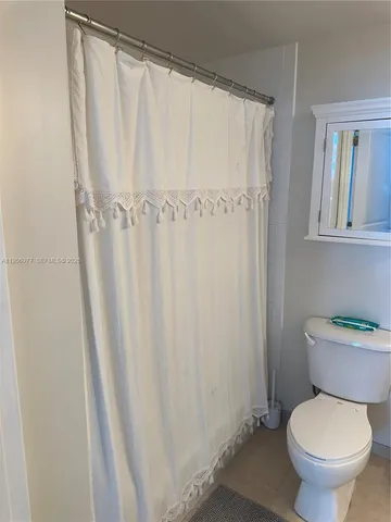 a white toilet sitting next to a shower