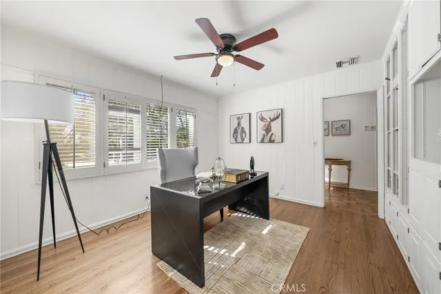 a dining room with wooden floor and a ceiling fan