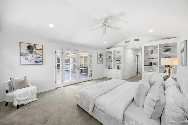 a spacious bedroom with a bed and glass walk in closet