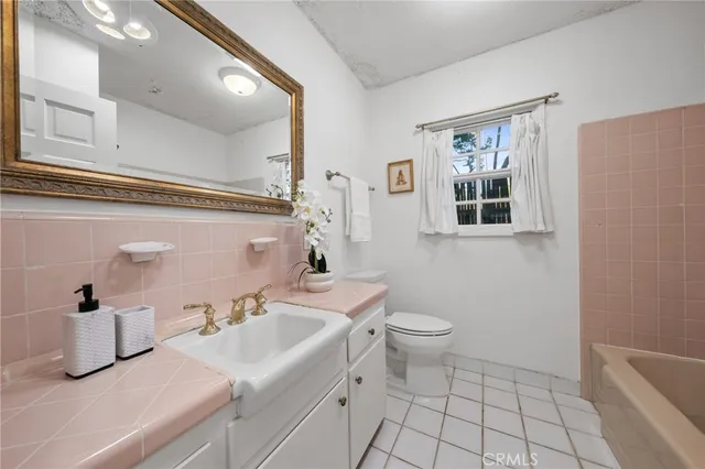 a bathroom with a sink a toilet and mirror
