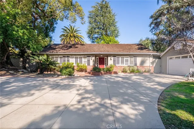 a view of a white house with a big yard and a large tree