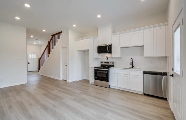 a view of a hallway with wooden floor and windows