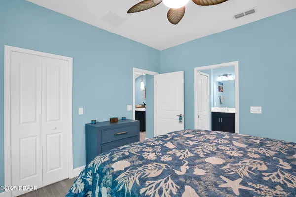 a bedroom with a large bed and a chandelier