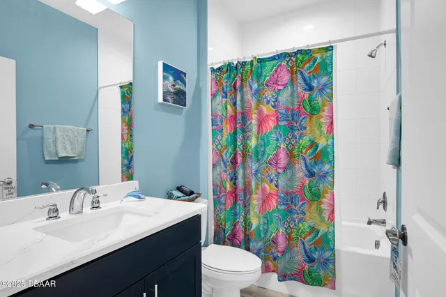 a bathroom with a sink a toilet and shower curtain