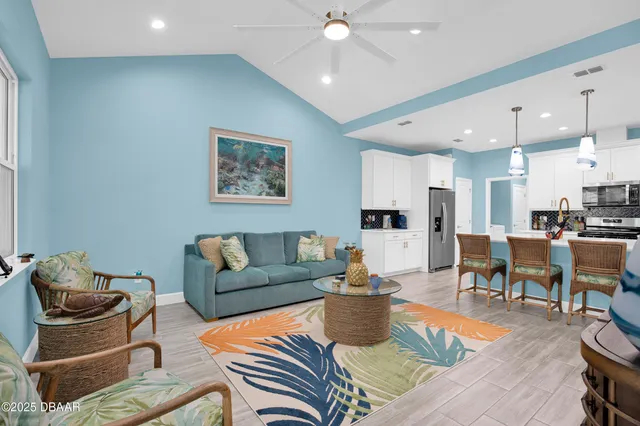 a living room with furniture kitchen view and a chandelier