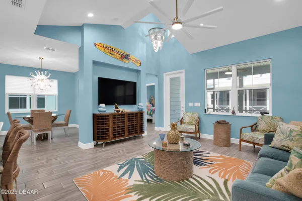 a living room with furniture a flat screen tv and a chandelier