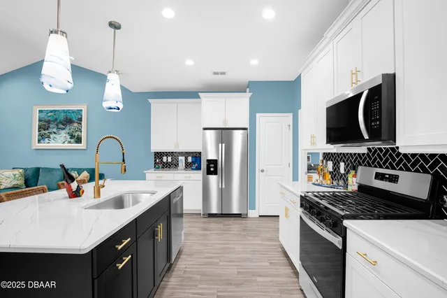 a kitchen with stainless steel appliances granite countertop a sink stove and refrigerator