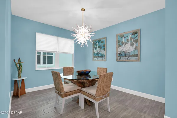 a dining room with furniture wooden floor a chandelier and a window