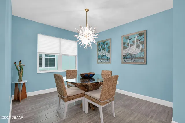 a dining room with furniture wooden floor a chandelier and a window
