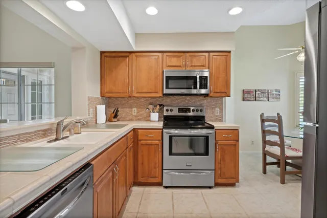 a kitchen with stainless steel appliances granite countertop a stove microwave and sink
