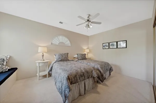 a spacious bedroom with a bed and a chandelier