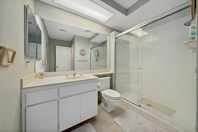 a bathroom with a double vanity sink toilet mirror and shower