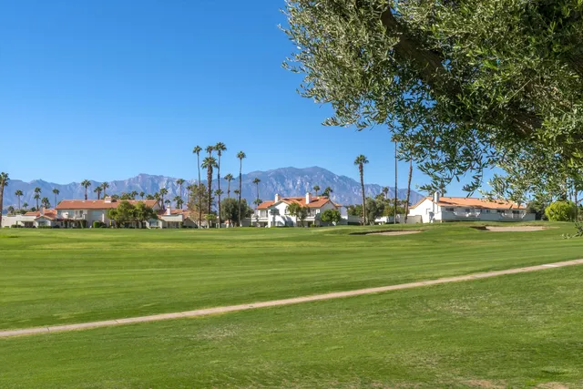a view of a grassy field with houses