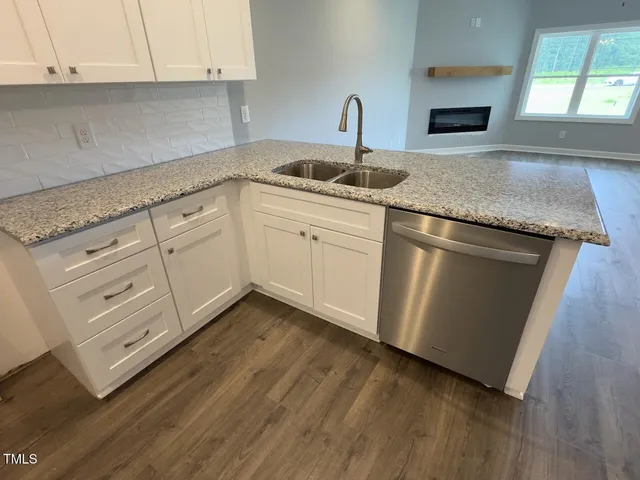 a kitchen with granite countertop white cabinets and white appliances