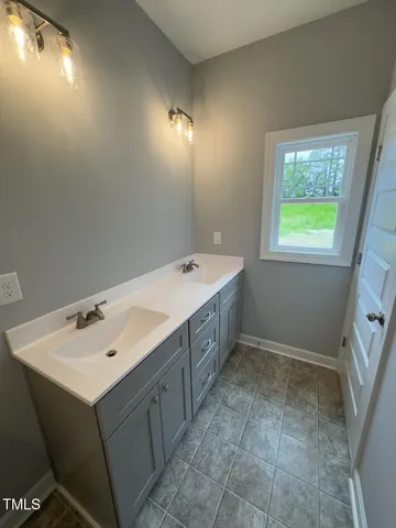 a spacious bathroom with a double vanity sink and a mirror