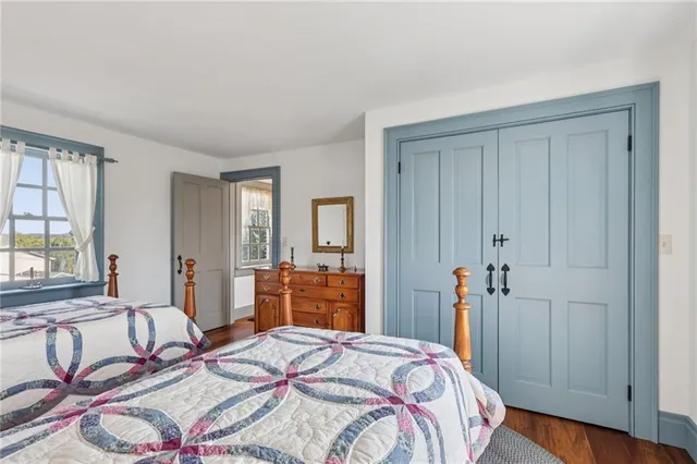 a bedroom with a bed and a dresser next to a window