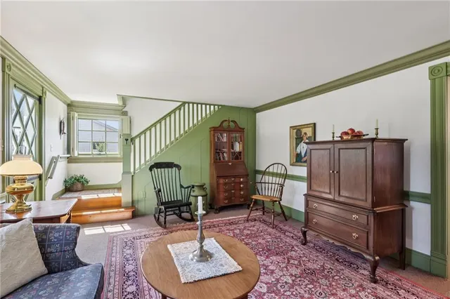 a living room with furniture a rug and kitchen view