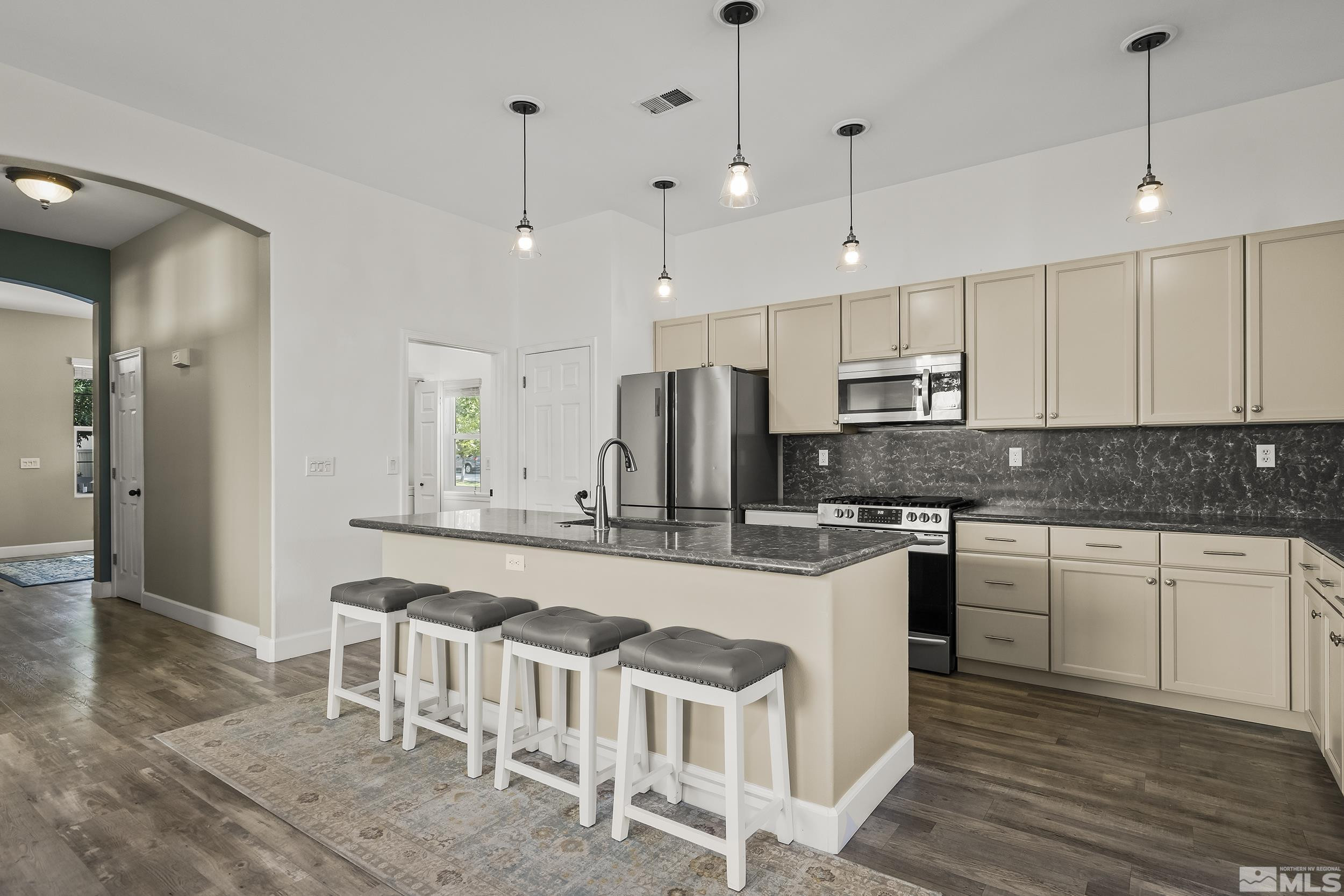 10245 Grizzly Hill Court Reno, NV 89521 - Photo 5 of 40 a large white kitchen with stainless steel appliances granite countertop a stove a sink and a refrigerator