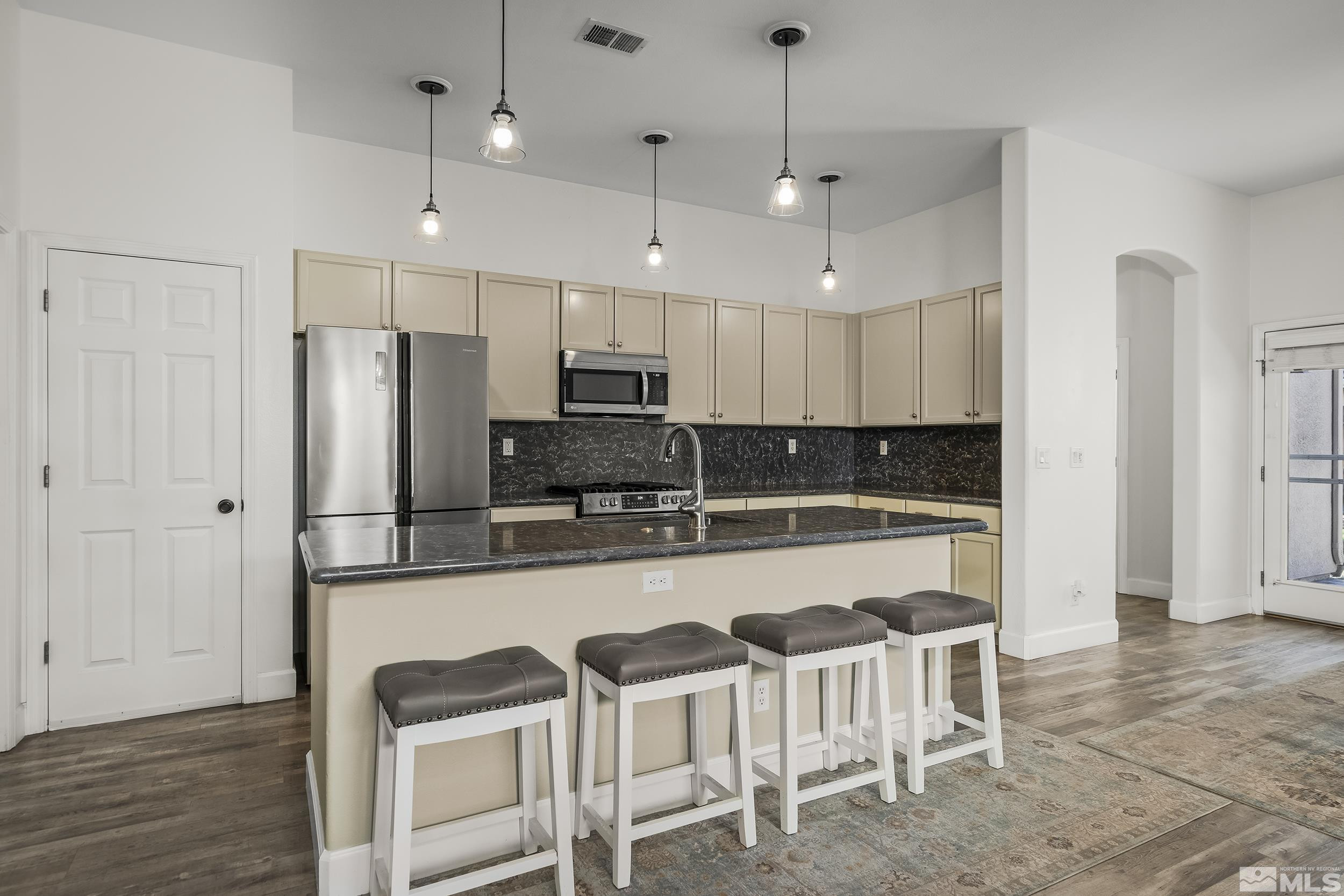 10245 Grizzly Hill Court Reno, NV 89521 - Photo 6 of 40 a kitchen with stainless steel appliances a refrigerator a stove a dining table and chairs